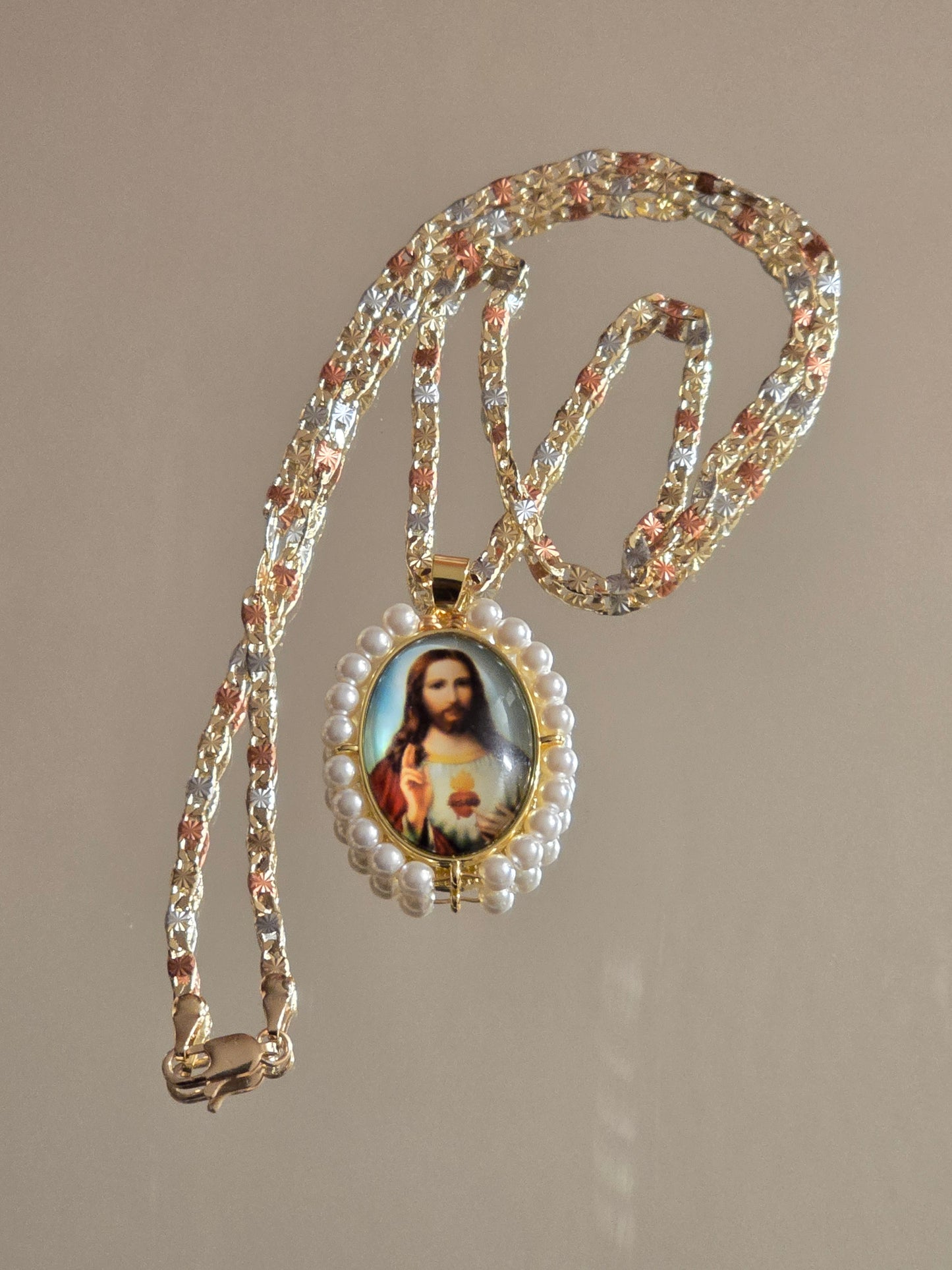 colgante ovalado del Sagrado Corazón de Jesús cuenta con perlas sintéticas y una cadena tricolor
