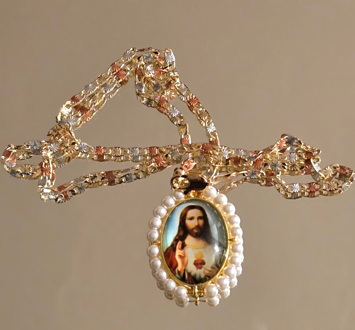 colgante ovalado del Sagrado Corazón de Jesús cuenta con perlas sintéticas y una cadena tricolor