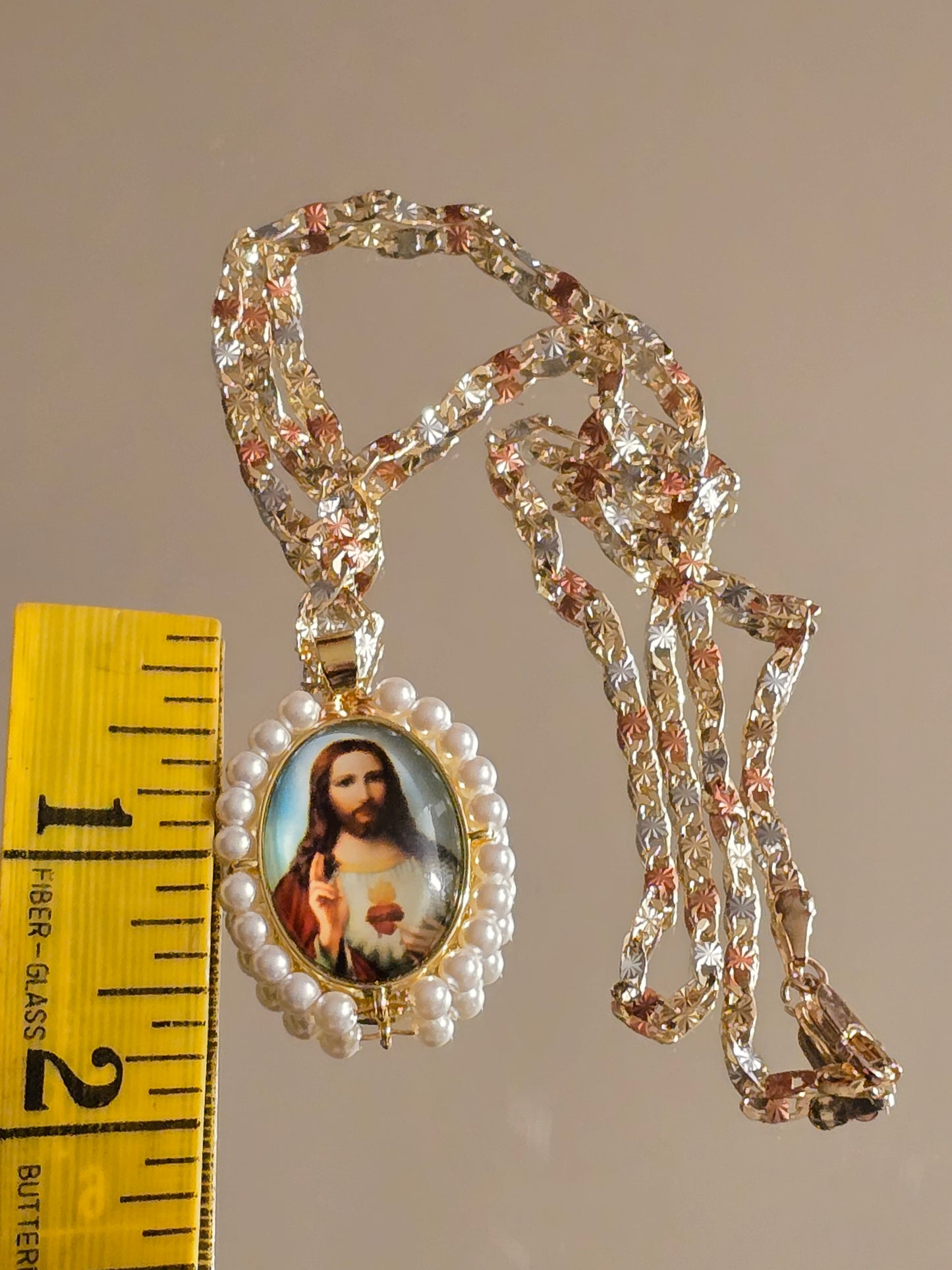 colgante ovalado del Sagrado Corazón de Jesús cuenta con perlas sintéticas y una cadena tricolor